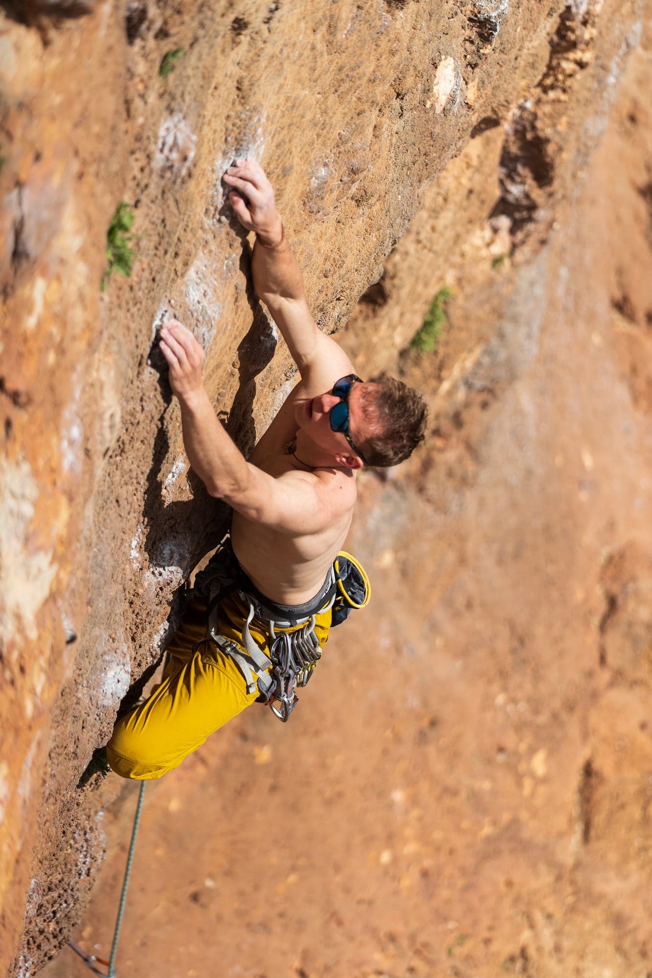 Alex Voit climbing an orange limestone wall
