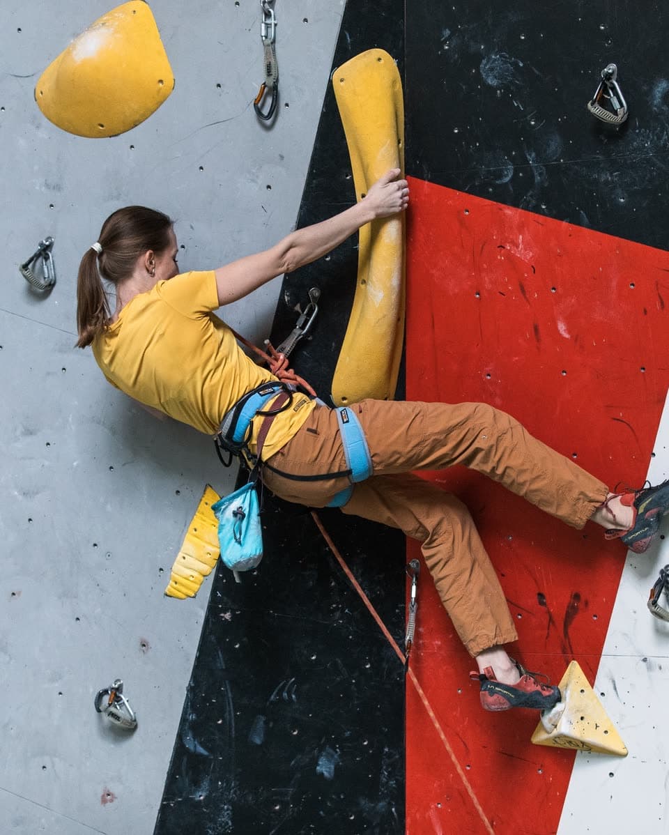 A climber leading a route in a gym